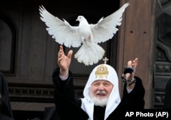 Russian Orthodox Church Patriarch Kirill releases a bird celebrating the Annunciation preceding the celebration of Orthodox Easter in front of the Christ the Savior Cathedral in Moscow on April 7.