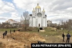 Bodies of civilians in plastic bags lie in a mass grave in Bucha on April 4.