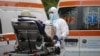 Ambulances wait in front of the University Hospital in Bucharest to hospitalize patients.
