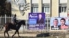 A man rides a horse past campaign posters for candidates in Kyrgyzstan's upcoming parliamentary elections in the village of Arashan, some 25 kilometers south of the capital, Bishkek. 