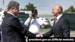 Moldovan Prime Minister Pavel Filip (right) and Ukrainian President Petro Poroshenko shake hands at the official opening of a joint border checkpoint at Kuchurgan-Pervomaisk.