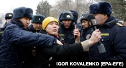 Police officers detain an Azattyk journalist who was covering a protest near the government building in Bishkek on January 10.