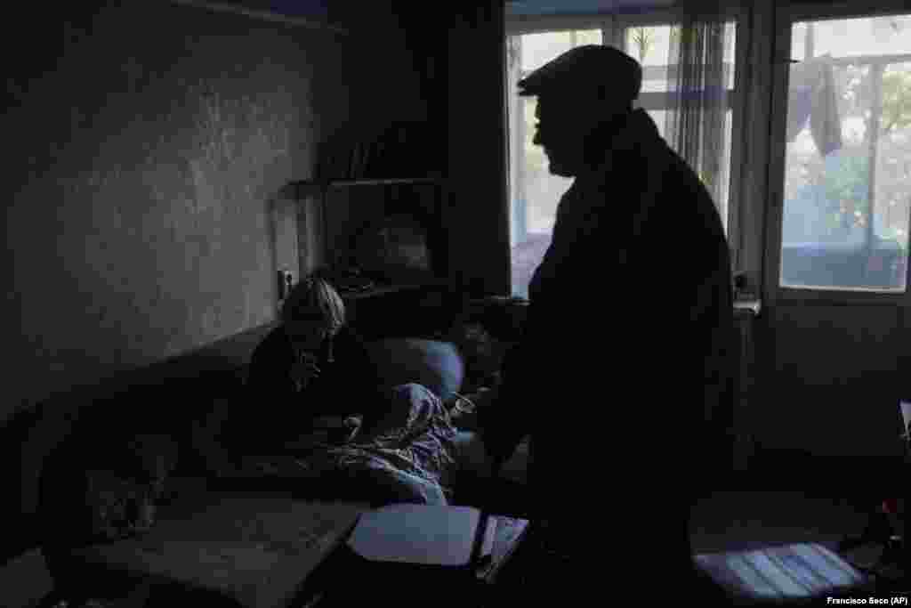 In the darkness of his cramped, musty apartment, Sevrukov&#39;s mother (left) sits under a blanket on a sofa piled with plates of spoiled food. Zoya Sevrukova says she&#39;s been bedridden for seven years, and that she spends most of her time seated, playing solitaire with a worn pack of cards.&nbsp;&quot;It&#39;s really cold now. If it weren&#39;t for my son, I would have frozen,&quot; she said.