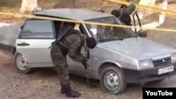 Kazakh police investigators examine a car at the site of an attack in Taraz that left eight people dead