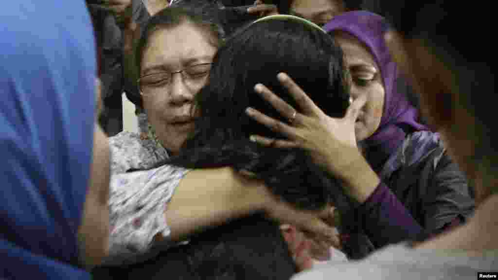 Relatives of a passenger of the missing Sukhoi aircraft grieve as the ill-fated plane&#39;s passenger list is checked at Halim Perdana Kusuma Airport in Jakarta.