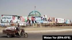 An Afghan man drives past parliamentary election campaign billboards for various political parties in Helmand in 2018, three years before the Talban takeover of the country. 