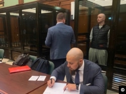 Ivan Safronov stands in the defendants' cell in Moscow City Court for the announcement of his verdict on September 5.