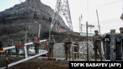 Azerbaijani troops stand guard at a checkpoint at the Lachin Corridor in December 2022.