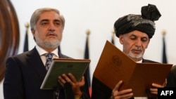 Afghan President Ashraf Ghani (right) administers the oath to Abdullah Abdullah as Afghanistan's newly created post of chief executive in Kabul on September 29.