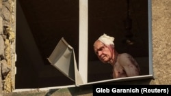 Wounded resident Volodymir, 66, looks out from inside his flat in an apartment building hit by a Russian military strike in Kramatorsk on July 7.