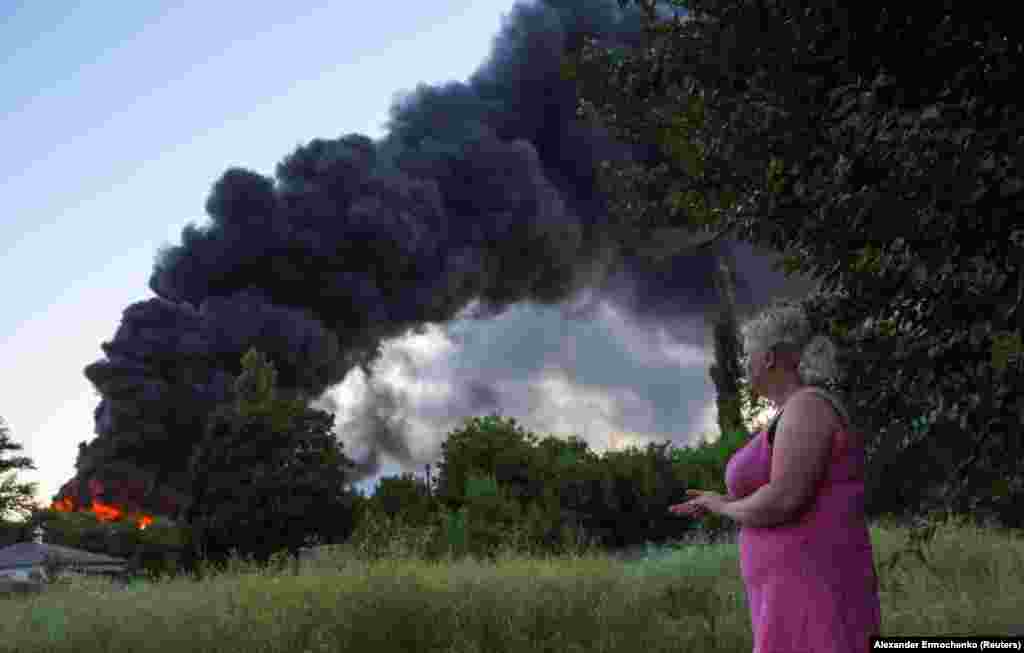 A resident watches the smoke and fires in Donetsk following shelling.