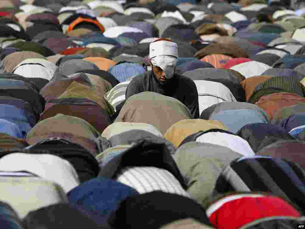 A wounded antigovernment protester joins in Friday Prayers at Tahrir Square in Cairo on February 4.