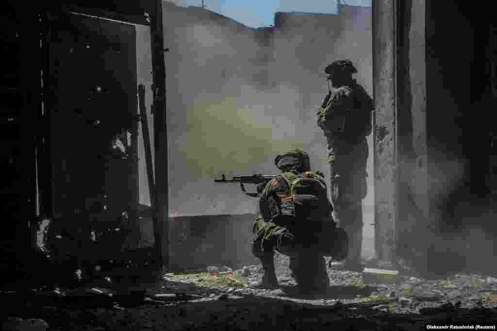 Ukrainian soldiers watch as a tank (not pictured) fires toward Russian troops in an industrial area of Syevyerodonetsk. &nbsp;