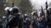 Riot police officers hold their weapons as they attempt to stop demonstrators protesting in Almaty on January 5, 2022. 