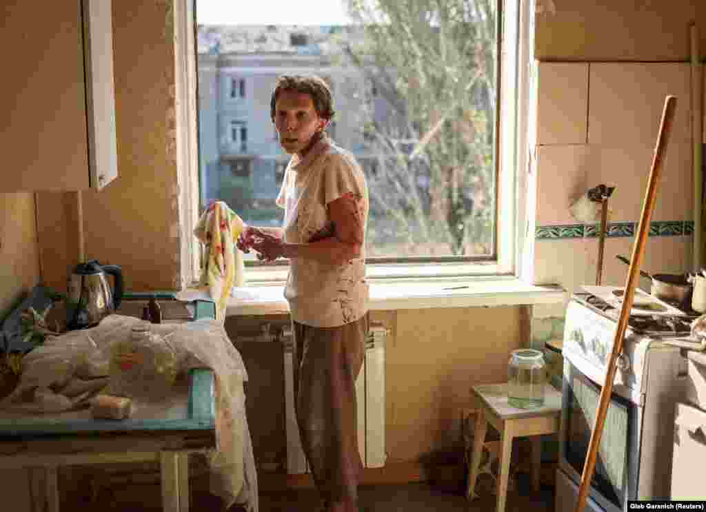 A bloodied Tetiana attempts to clean her home after it was damaged during a military strike on Kramatorsk.