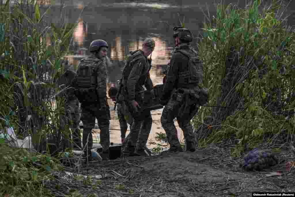 Ukrainian soldiers transport ammunition brought over by raft.