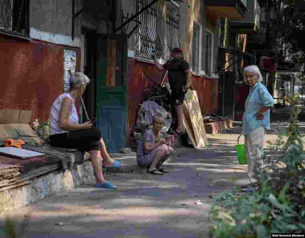 Residents gather in front of their damaged apartment building in Kramatorsk after it was hit by a military strike.