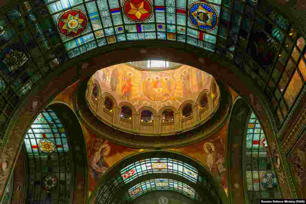 A shot of the interior of the church under the main dome shows a stained-glass emblem in the top right that features the communist hammer and sickle.