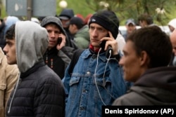 Russian men line up to get Kazakh registrations after crossing the border into Kazakhstan from the Mariinsky border crossing on September 28, 2022.