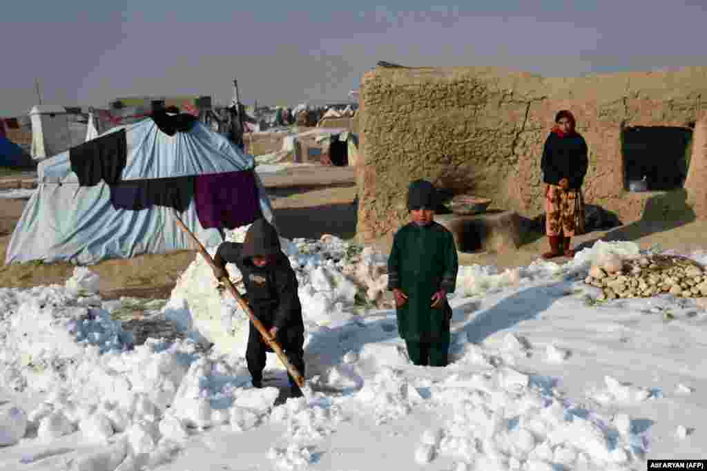 Children at a camp for internally displaced people (IDPs) shovel snow near their tents in the Nahr-e-Shahi district of Balkh Province, near Mazar-i-Sharif, on January 17. Kabul and several other provinces have seen record-low temperatures since January 10, with Ghor in the central region reaching the lowest reading of -33 Celsius (-27 Fahrenheit). &nbsp;