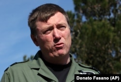 RAF Air Vice Marshal Greg Bagwell speaks at a press conference at an air base near Bari, southern Italy, in 2011.