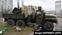 Bodies of Russian servicemen, wearing Ukrainian uniforms, inside and beside a vehicle. They were shot during a skirmish in the Ukrainian capital, Kyiv, on February 25.