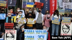 People hold placards during a protest against Russia's invasion of Ukraine outside the Russian representative office in Taipei on March 1.