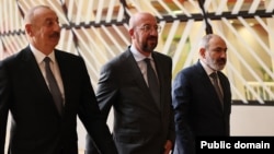 Azerbaijani President Ilham Aliyev (left) and Armenian Prime Minister Nikol Pashinian (right) walk with EU Council President Charles Michel on August 31, 2022.