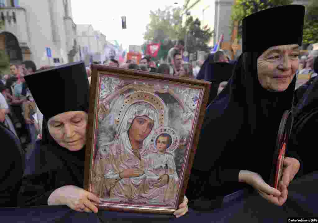 Thousands of Orthodox Christians carrying crosses, religious icons, and banners chanted and prayed as they gathered outside the Church of St. Sava in Belgrade on August 28 to protest a gay pride event.