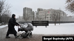 A woman pushes a pram past the U.S. Embassy in Kyiv on January 24. 