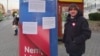 Activist Peter Heindl stands next to a poster promoting the Hungarian government's slogan of "Hungary goes forward! Not backward!" in 2021. He says the billboards are unconstitutional and has reported the campaign to prosecutors.