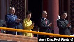 Former Kazakh President Nazarbaev (left) is seen with presidents Vladimir Putin of Russia and Xi Jinping of China (right) at a military parade. (File photo) 