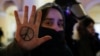 A demonstrator shows a peace symbol painted on her hand as she stands next to a riot police officer during an anti-war protest against Russia's invasion of Ukraine in St. Petersburg on March 2.