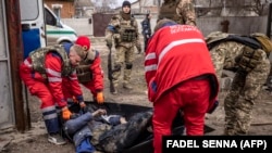 Ukrainian medics remove the body of a Russian soldier after Kyiv's forces retook the village of Mala Rohan, east of Kharkiv, on March 30.