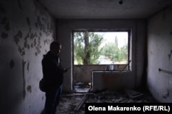 Ihor stands in his mother's room of their damaged apartment.