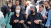 Women wearing head scarves walk in the streets of Tehran on July 12. Since the country's 1979 Islamic revolution, Iranian law requires all women to wear a hijab that covers the head and neck while concealing the hair. But many have pushed the boundaries over the past two decades.