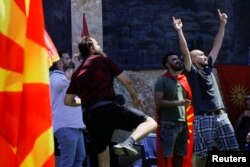 A supporter of VMRO-DPMNE, North Macedonia's biggest opposition party, throws an egg on the parliament building during a rally in Skopje on July 14.