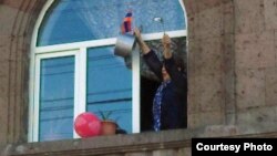 A woman celebrates the resignation of Armenian Prime Minister Serzh Sarkisian by banging on a cooking pot at her home in Yerevan on April 23.