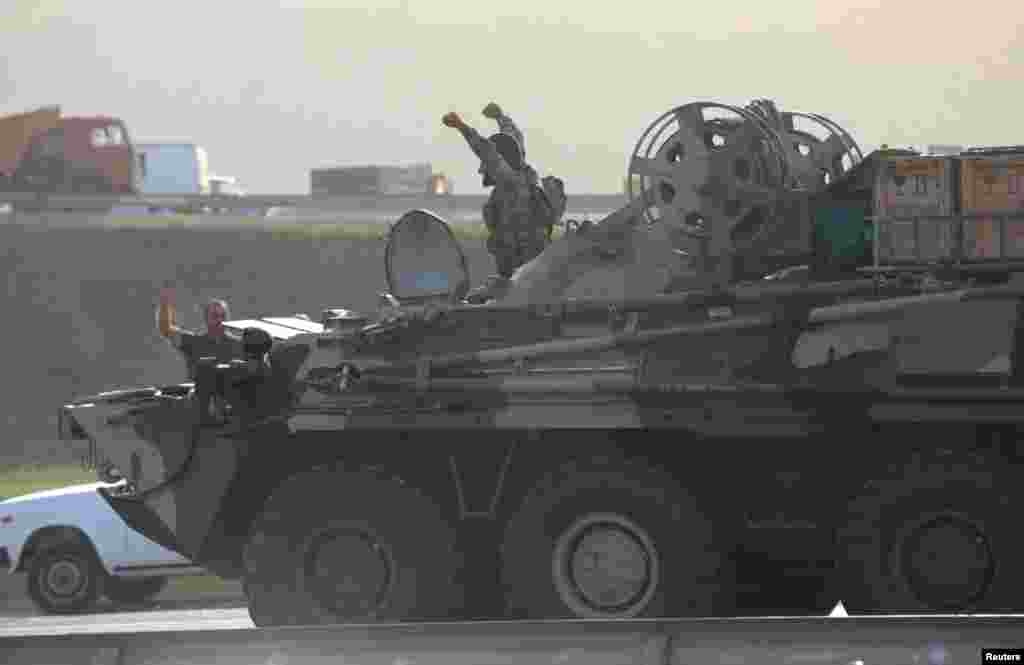 An Azerbaijani service member in an armored personnel carrier greets well-wishers on a roadside in Baku.