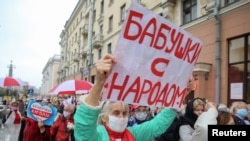 Opposition supporters, mostly pensioners, attend a rally to reject the presidential election results in Minsk on October 12. The poster reads "Grandmas with the people."