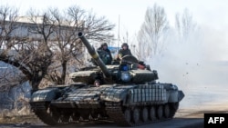 A Ukrainian tank drives on a road not far from the eastern Ukrainian city of Debaltseve on February 13, 2015. 