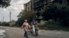 Residents walk past a war-damaged building in the center of the recently liberated town of Izyum in Ukraine's Kharkiv region on September 13. 