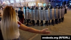 A woman gestures toward riot police in the city of Homel on August 10.