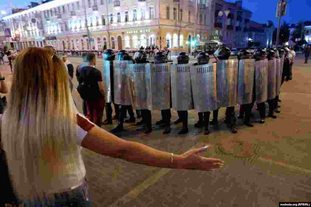 A woman gestures toward riot police in the city of Homel on August 10.