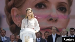 Yevhenia Tymoshenko, daughter of Yulia Tymoshenko, addresses supporters of opposition parties in front of a screen displaying a picture of her jailed mother at a May 12 rally in Kyiv.