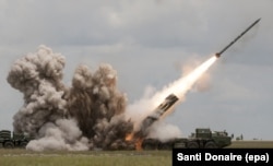 A Smerch rocket being launched during training. Each rocket weighs around 800 kilograms and is 7.6 meters long. A salvo of 12 rockets can be fired in less than a minute.