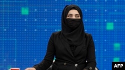 A female presenter for TOLOnews, Thamina Usmani, covers her face in a live broadcast in Kabul on May 22.