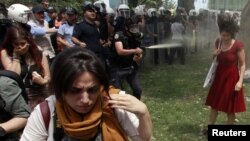 In a photo adopted by protesters as a symbol of their struggle, a Turkish policeman uses tear gas against a woman during a rally in Taksim Square in central Istanbul on May 28.