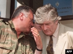 Bosnian Serb leader Radovan Karadzic (right) listens to Bosnian Serb military commander Ratko Mladic during a meeting with the press in Pale on August 5, 1993.