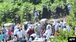 The scene as Serbian Prime Minister Aleksandar Vucic and his delegation, escorted by security forces, leave Srebrenica-Potocari Memorial cemetery on June 11.